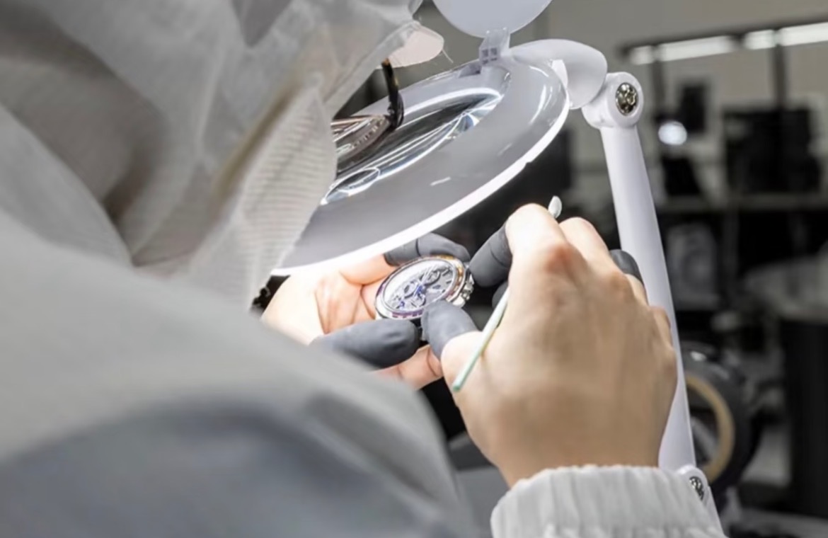 Detailed watch inspection under a magnifying lamp